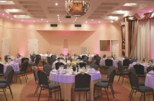 圣达菲InterTower Hotel的一个带桌椅和紫色桌子设置的宴会厅