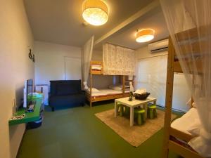 直岛町Bamboo Village Guest House的小房间设有双层床和沙发