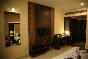 班加罗尔WEST FORT HOTEL的酒店客房设有电视和卧室