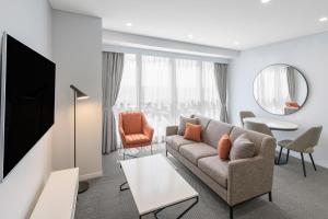 布里斯班Meriton Suites Adelaide Street, Brisbane的客厅配有沙发和桌子
