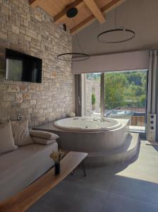 梅加克瑞奥Evora Luxury Suites的带浴缸和沙发的大型浴室