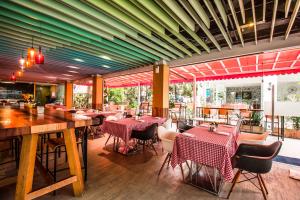 南芭堤雅Kudos Parc Pattaya的一间在房间内配有桌椅的餐厅