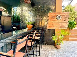 南芭堤雅Kudos Parc Pattaya的餐厅内带桌椅的酒吧