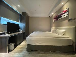 高雄好地方饭店六合馆的一间卧室配有一张床和一台平面电视