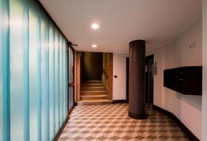 米兰Easylife - Moderno bilocale in zona Porta Romana的走廊上设有柱子,铺着瓷砖地板