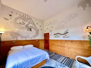 满洲乡Wild East Country House的卧室配有一张床,墙上挂有绘画作品