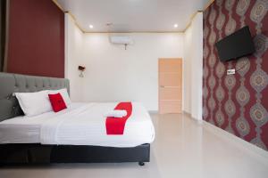 DukuRedDoorz Syariah near Minangkabau International Aiport的一间卧室配有一张红色椅子的床
