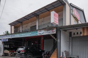 DukuRedDoorz Syariah near Minangkabau International Aiport的停在商店前的一辆黑色汽车