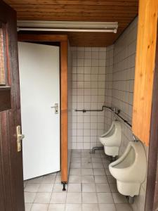 加格瑙Zeltplatz Großer Wald的浴室设有3个小便室、1扇门和2个卫生间