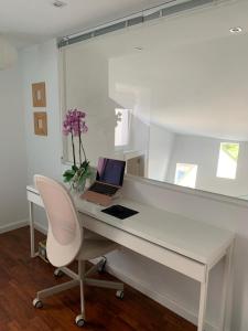 ViavélezLa Postoca的一张带笔记本电脑和椅子的白色书桌