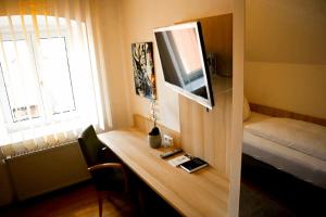 诺德林根Weinstube Sinas Brettl的客房设有一张桌子、一台电视和一张床