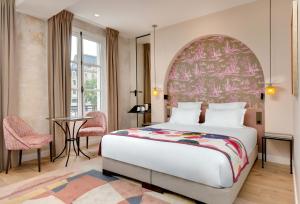 巴黎圣母海岸酒店的一间卧室配有一张大床和一张桌子
