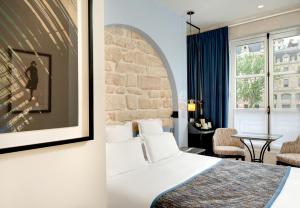 巴黎圣母海岸酒店的酒店客房配有一张床铺和一张桌子。