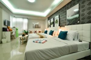清迈Sphat เอสพลัส Boutique Hotel chiang mai的一间大卧室,配有两张床和一张桌子
