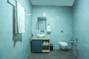 阿姆利则Hotel Grand Cabbana By Levelup Hotels的蓝色的浴室设有水槽和卫生间