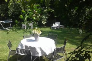泽德尔海姆THE FACTORY, retreat near Bruges的一张带椅子的白色桌子和花瓶