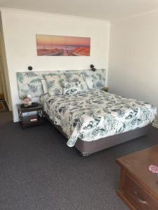 曼哲拉Tranquility at Mandurah Apartments的一间卧室配有一张床和一张桌子