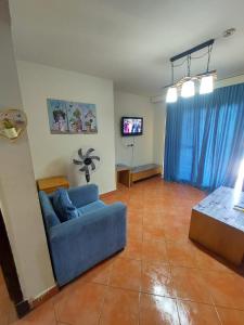 艾因苏赫纳Private Chalets in Porto Sokhna Pyramids - Families Only的客厅配有蓝色的沙发和电视