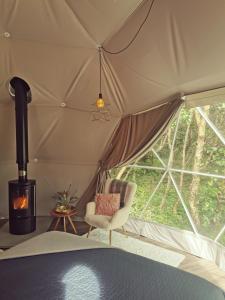 斯莱戈Teapot Lane Glamping - Adults only的带椅子和壁炉的帐篷客房