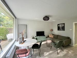 奥特罗Modern natuurhuisje midden in het bos op de Veluwe - Beau Home的客厅配有沙发和桌椅