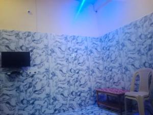 DongargarhIndian Family Lodge, Rajnandgaon, Chhattisgarh的一间设有白色墙壁、桌子和电视的客房