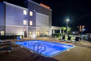 维多利亚Comfort Inn & Suites Victoria North的一座游泳池,在晚上在建筑物前