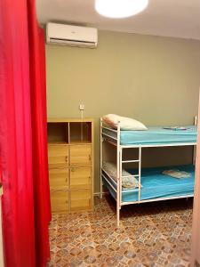 马拉加Cathedral Malaga Hostel的带两张双层床和梳妆台的客房