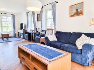 栋堡Prachtig vakantiehuis in Domburg DO38的客厅配有蓝色的沙发和桌子