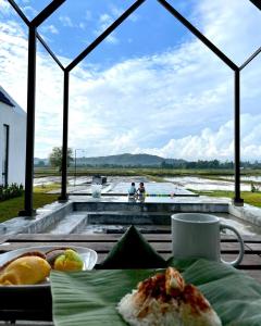珍南海滩Ezu Isle Langkawi Pool Villa的一张桌子,上面放着一盘食物,享有水景