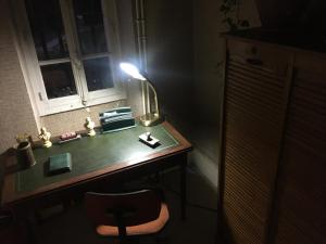VitteauxGamotel的黑暗的房间里一张桌子,上面有台灯和椅子