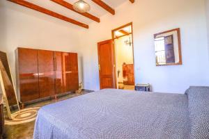 阿罗纳Rentaliday Casa Saro的一间卧室配有一张床和一个木制橱柜
