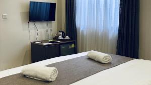 FuvahmulahIsle Royal Inn的酒店客房,配有带毛巾的床