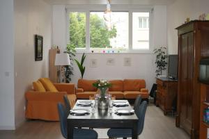 斯特拉斯堡R-appartements Strasbourg cosy Orangerie pour vos séjours en famille ou entre amis的客厅配有桌子和沙发