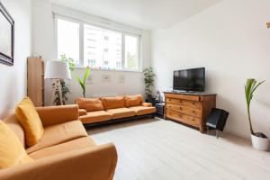 斯特拉斯堡R-appartements Strasbourg cosy Orangerie pour vos séjours en famille ou entre amis的带沙发和电视的客厅