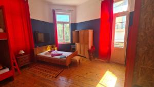 海若克利欧Doukas Hostel Room的一间设有红色窗帘的卧室和一张位于客房内的床