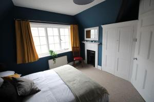 考斯Pier View 2 Bedroom Apartment的蓝色的卧室设有床和窗户