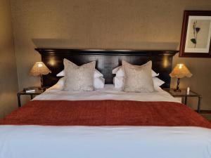 比勒陀利亚Bass Lake Country Lodge的一张带红色毯子和枕头的大床