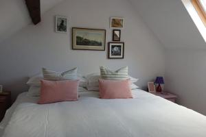 帕兹托Grocer John's. The heart of the old town的卧室配有白色床和粉红色枕头