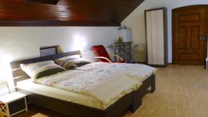 斯特拉特纳斯达卡玛宾馆的一间卧室配有一张大床和一张红色椅子