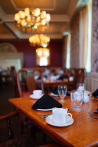 夏洛特顿罗德夏洛特敦酒店的木桌,带盘子和杯子,玻璃杯