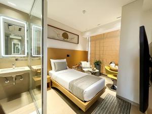 加尔各答Morvee Hotels Alipore Kolkata的一间卧室配有一张床,浴室设有水槽