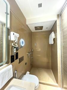 加尔各答Morvee Hotels Alipore Kolkata的带淋浴、卫生间和盥洗盆的浴室