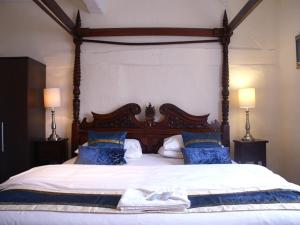 阿默舍姆THE SARACENS HEAD INN的一间卧室配有一张带蓝色枕头的大床