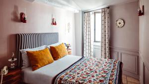 巴黎Maison Saintonge的一间卧室配有一张带黄色枕头的床和一扇窗户
