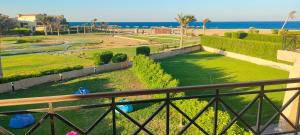 艾因苏赫纳Villa at Piacera Resort-seaview的阳台享有公园和海洋的景致。