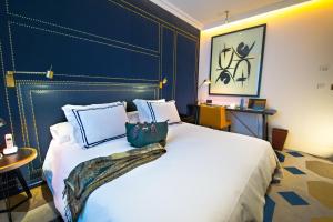 马德里马德里唯一精品酒店的一间卧室配有一张白色大床和蓝色床头板