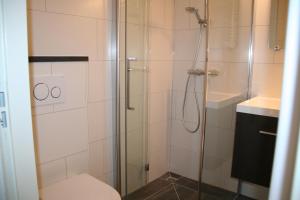 尼乌弗利特Schorrebloem 10的带淋浴、卫生间和盥洗盆的浴室