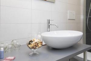 波代诺内Dépendance Ragaraja con sauna e idromassaggio的一个带水槽和碗在柜台上的浴室