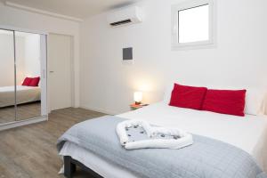 波代诺内Dépendance Ragaraja con sauna e idromassaggio的卧室配有带红色枕头的大型白色床