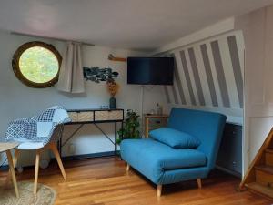 梅斯Appartement atypique indépendant sur péniche的客厅配有蓝色椅子和书桌